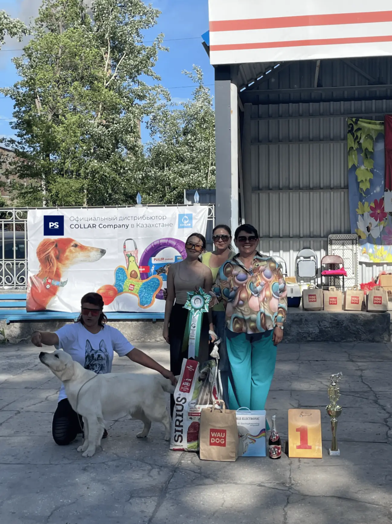 Победители выставки рядом с баннером PETSOLUTIONS и призами